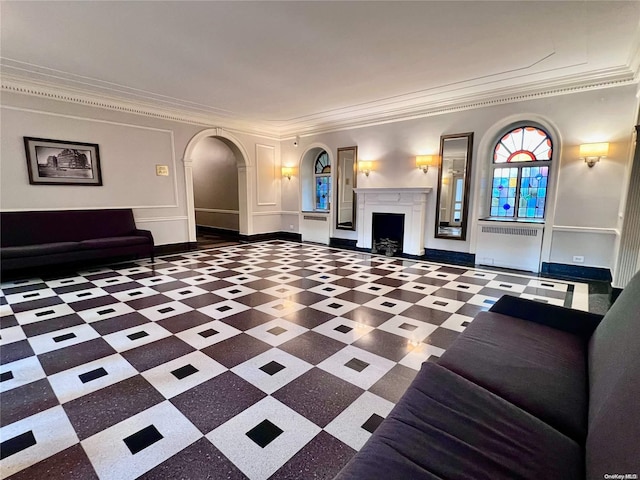 unfurnished living room with radiator heating unit and crown molding