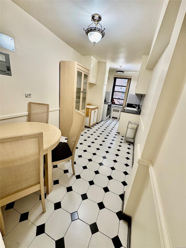 kitchen featuring white cabinets, a sink, and light floors