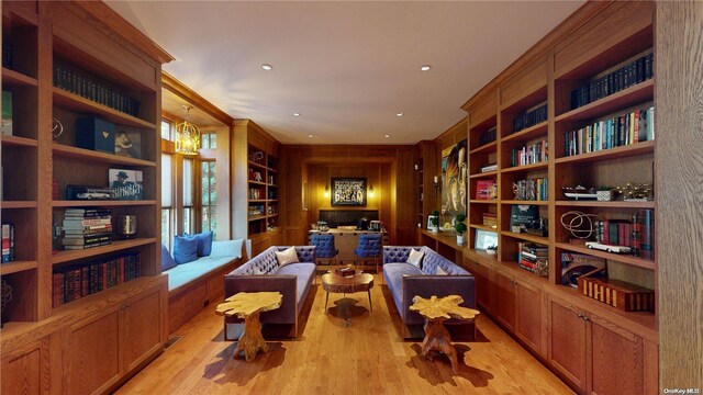 sitting room featuring a notable chandelier, built in features, and light hardwood / wood-style flooring