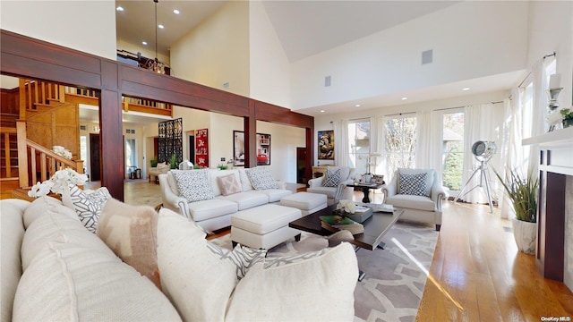 living room with high vaulted ceiling and light hardwood / wood-style flooring