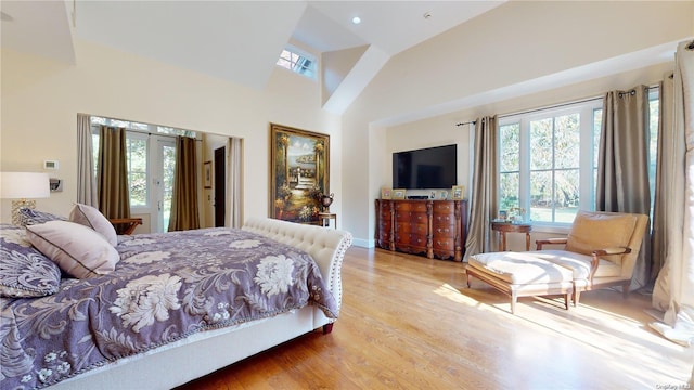 bedroom with light hardwood / wood-style floors and high vaulted ceiling