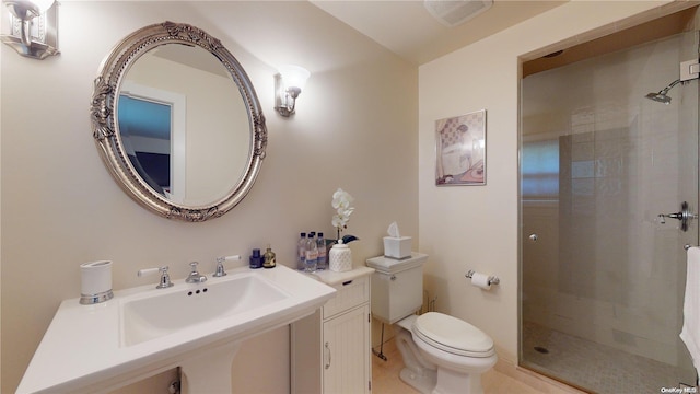 bathroom with tile patterned floors, sink, toilet, and tiled shower