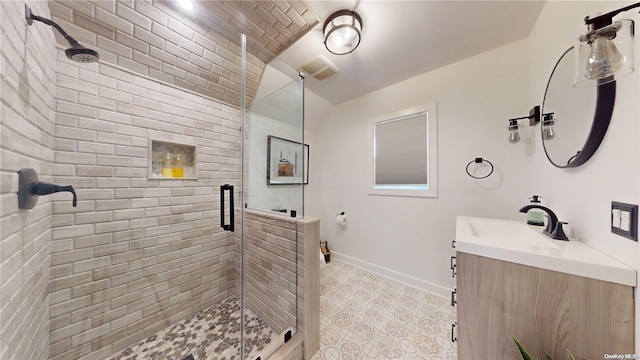 bathroom with vanity, lofted ceiling, and a shower with door