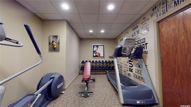 workout room featuring carpet and a paneled ceiling