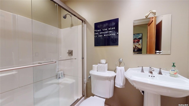 bathroom featuring toilet, an enclosed shower, and sink