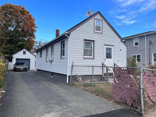 view of front of house featuring a garage and an outbuilding