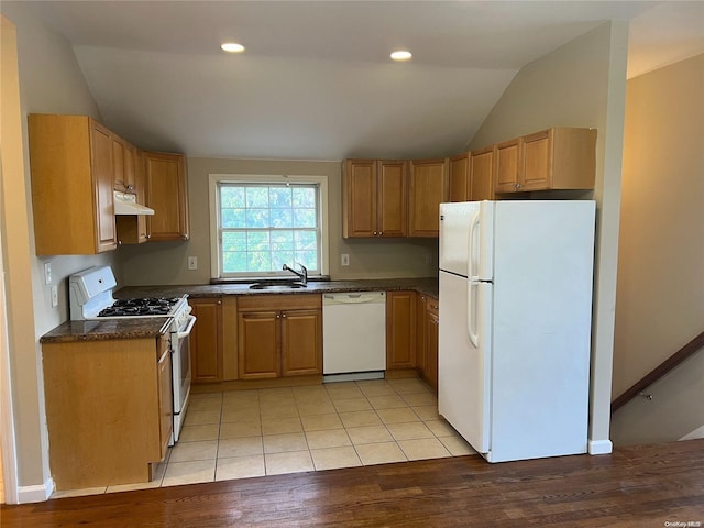 kitchen with sink, light hardwood / wood-style flooring, dark stone counters, vaulted ceiling, and white appliances