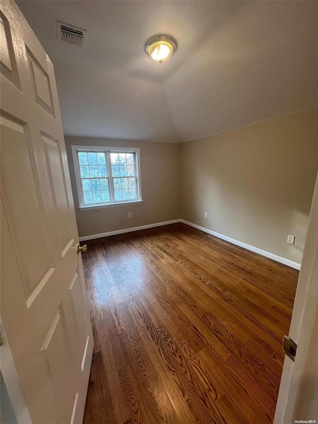 interior space featuring lofted ceiling and dark hardwood / wood-style floors