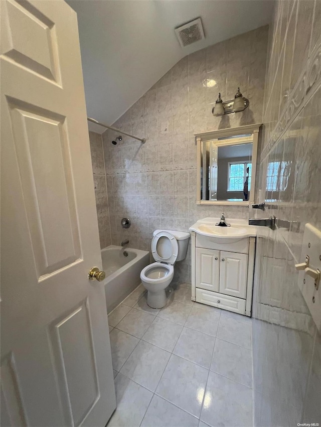 full bathroom with tile patterned flooring, vanity, tile walls, and lofted ceiling