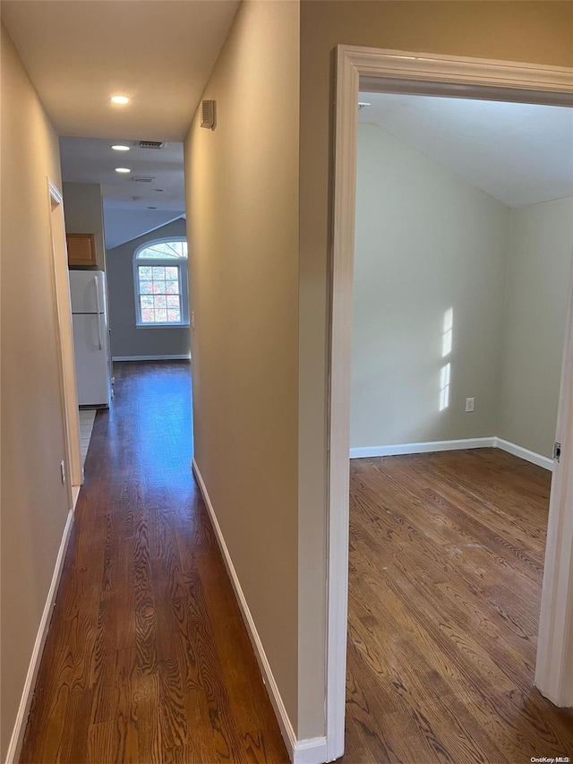 corridor featuring dark hardwood / wood-style floors and lofted ceiling