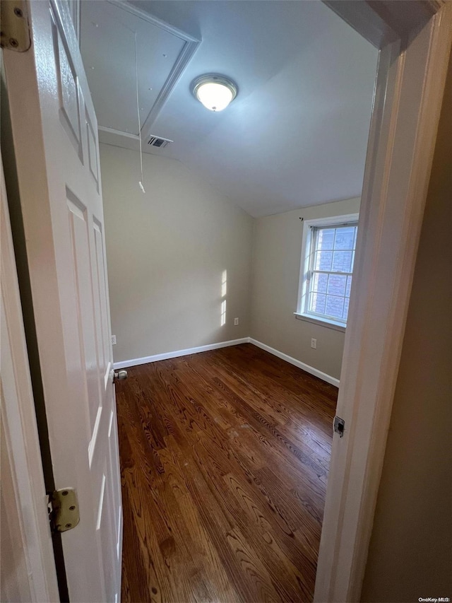 unfurnished room with hardwood / wood-style floors and vaulted ceiling