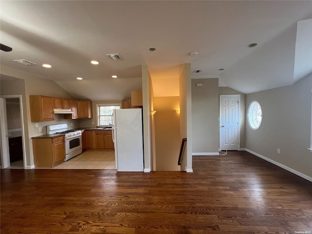 kitchen with hardwood / wood-style flooring, white appliances, and vaulted ceiling