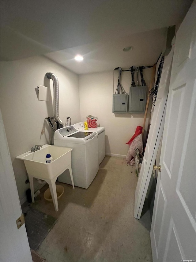 laundry room with electric panel, washer and clothes dryer, and sink