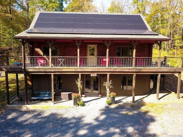 view of front facade with solar panels, a patio area, and french doors