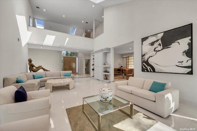 living room featuring a high ceiling, a wealth of natural light, and light tile patterned flooring