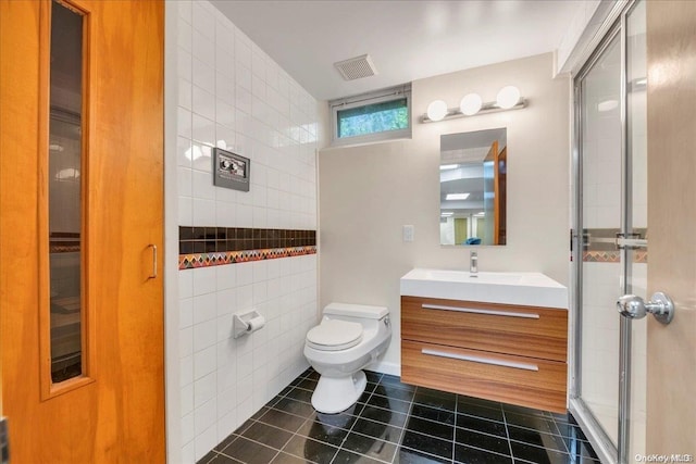 bathroom with vanity, tile patterned flooring, toilet, tile walls, and an enclosed shower