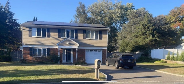 view of front of home featuring solar panels, a garage, and a front lawn