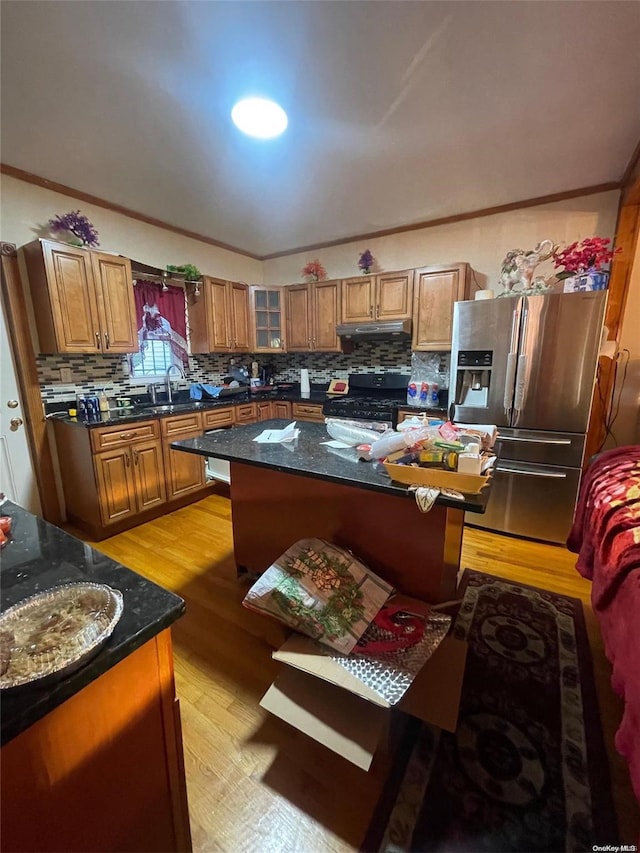 kitchen featuring backsplash, stainless steel fridge with ice dispenser, a kitchen island, and light hardwood / wood-style floors