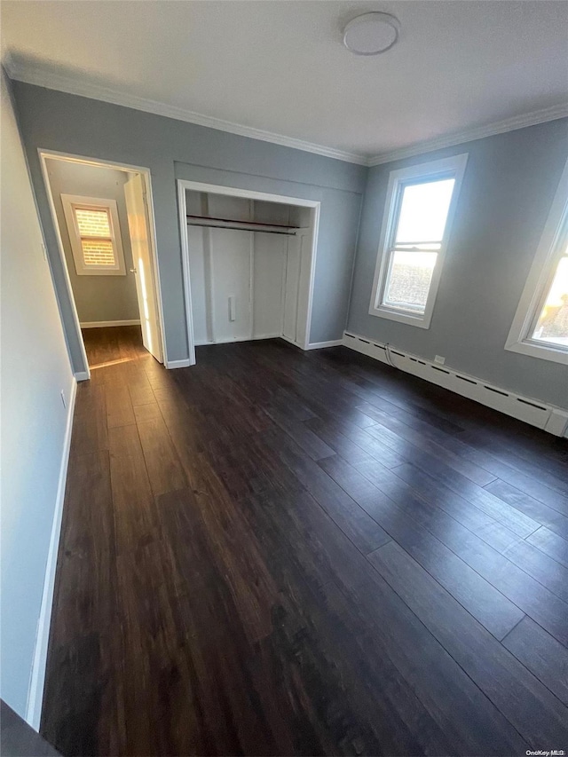 unfurnished bedroom with dark hardwood / wood-style floors, ornamental molding, a baseboard radiator, and a closet