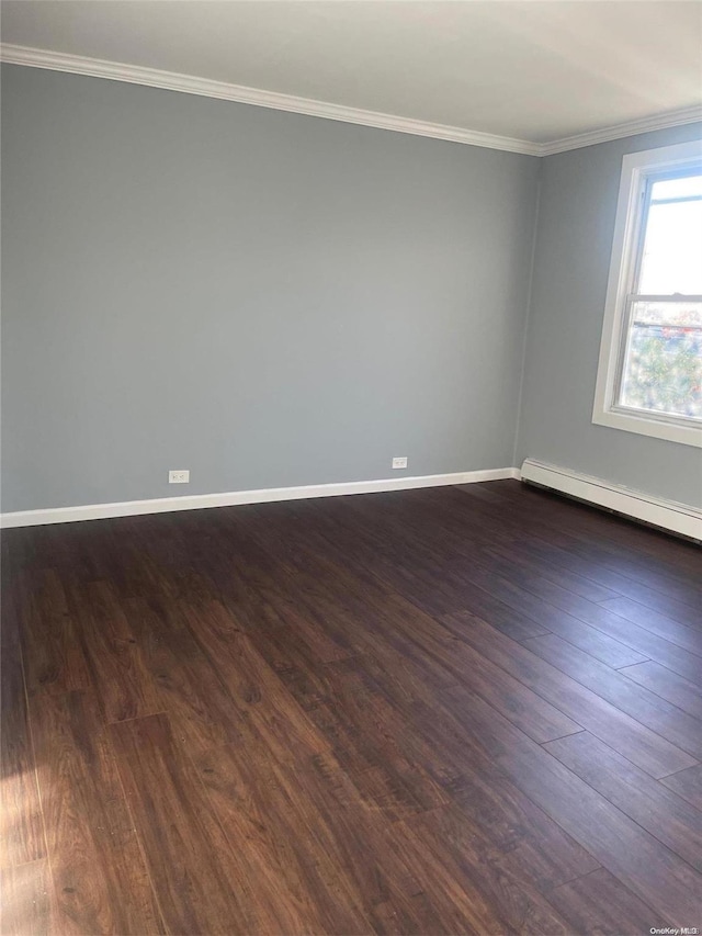 empty room featuring ornamental molding, a baseboard heating unit, and dark wood-type flooring