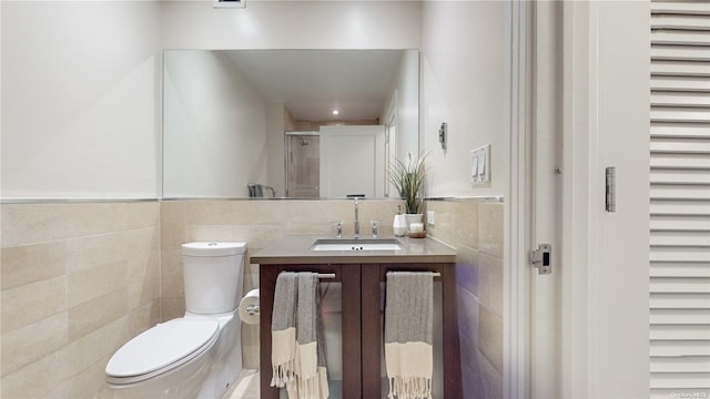 bathroom featuring an enclosed shower, vanity, toilet, and tile walls