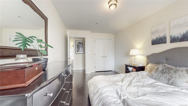 bedroom with dark hardwood / wood-style flooring and a closet