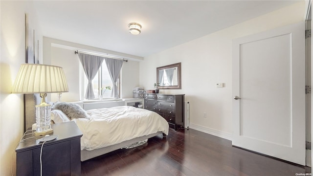 bedroom with dark hardwood / wood-style floors