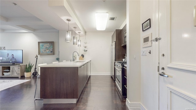 kitchen with appliances with stainless steel finishes, dark brown cabinets, dark wood-type flooring, and sink