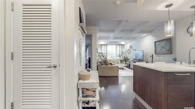 interior space with beam ceiling, dark hardwood / wood-style flooring, sink, and coffered ceiling