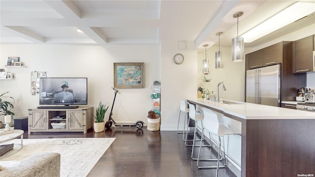 interior space featuring hanging light fixtures, high end refrigerator, dark hardwood / wood-style floors, kitchen peninsula, and dark brown cabinets