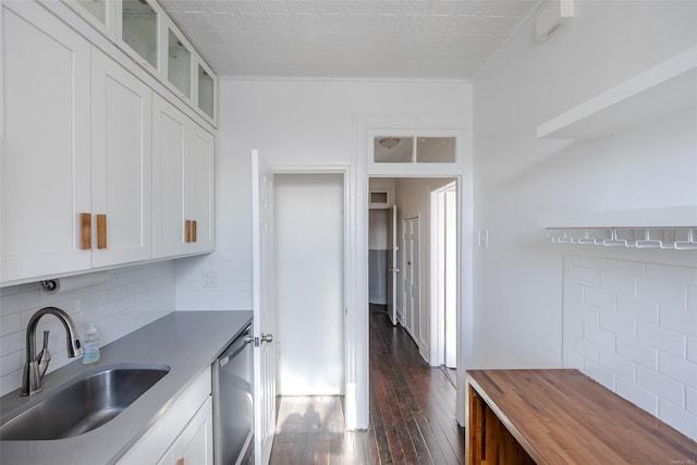 kitchen featuring dark wood-type flooring, stainless steel dishwasher, sink, and white cabinets