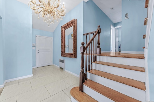 tiled entrance foyer with a notable chandelier, radiator heating unit, and vaulted ceiling