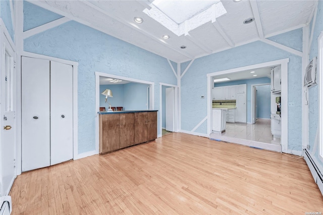 unfurnished bedroom with vaulted ceiling, a baseboard radiator, and light hardwood / wood-style flooring