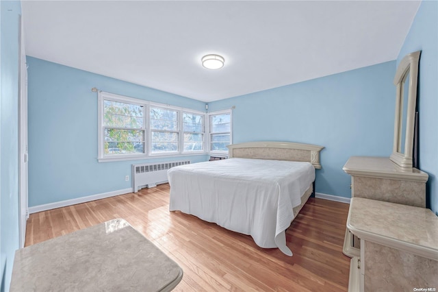 bedroom with wood-type flooring and radiator