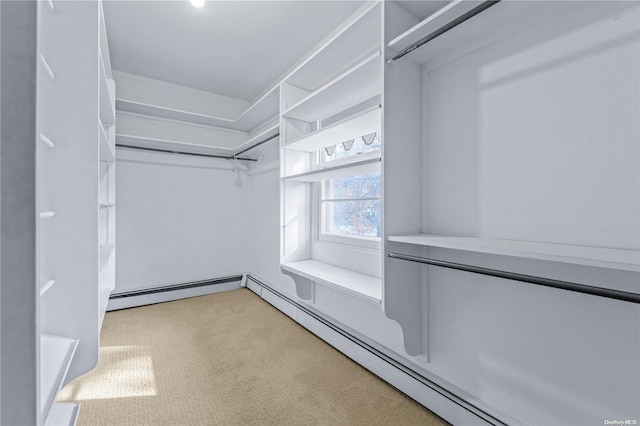 spacious closet with light colored carpet and a baseboard heating unit