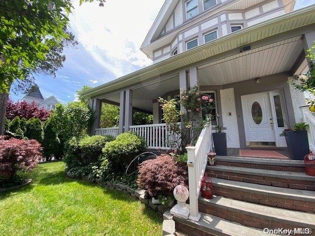 property entrance featuring a porch and a lawn