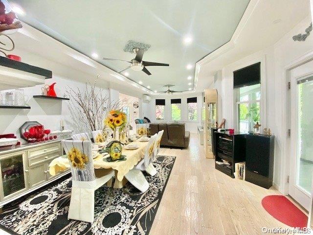 dining area with a wealth of natural light, ceiling fan, ornamental molding, and light wood-type flooring