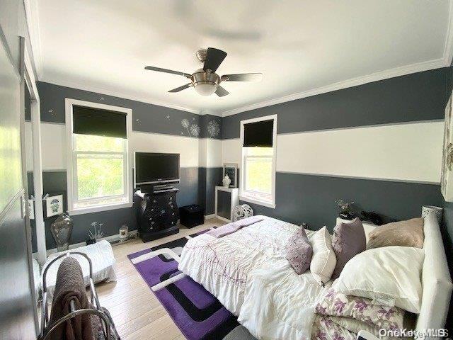 bedroom with ceiling fan, light wood-type flooring, and ornamental molding