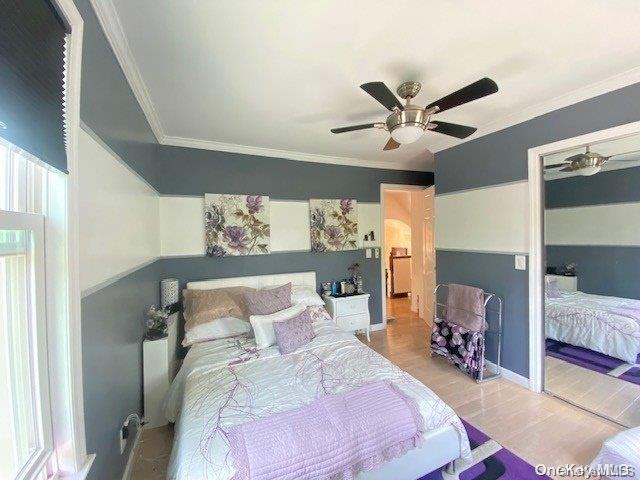 bedroom with light wood-type flooring, ceiling fan, and crown molding