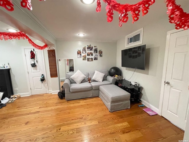 living room featuring crown molding and light hardwood / wood-style flooring