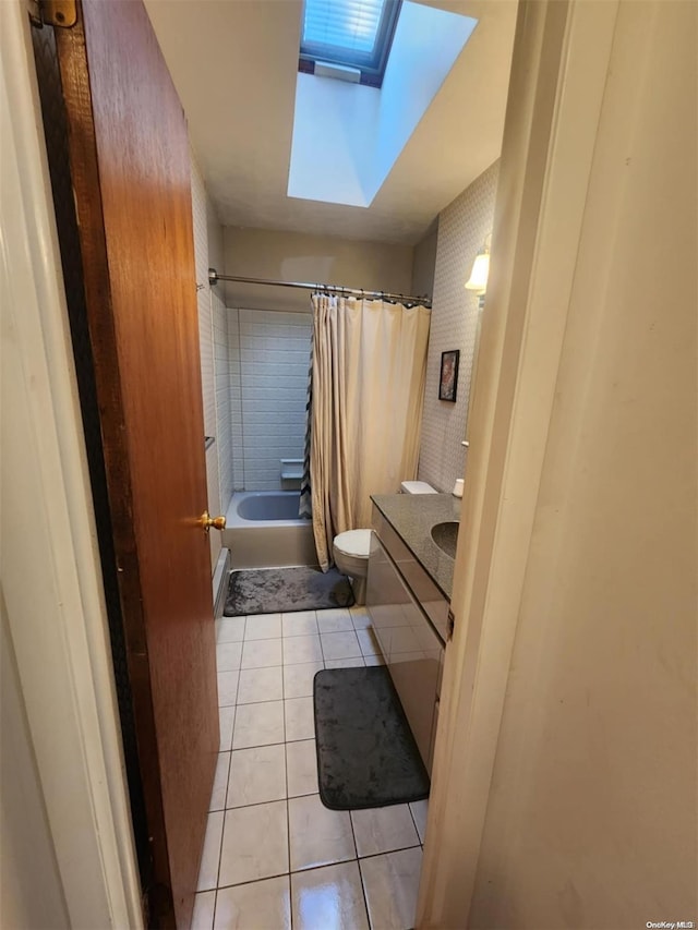 full bathroom with vanity, tile patterned floors, shower / bath combination with curtain, a skylight, and toilet