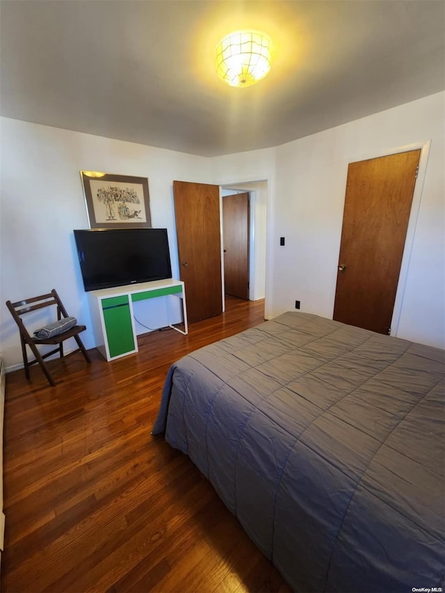 bedroom with dark hardwood / wood-style floors