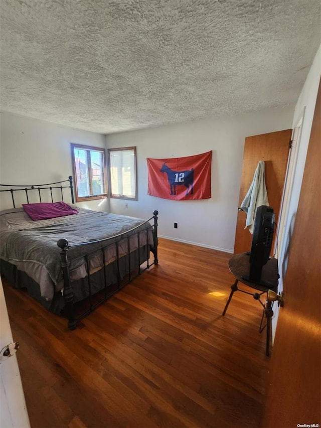 bedroom with wood-type flooring and a textured ceiling