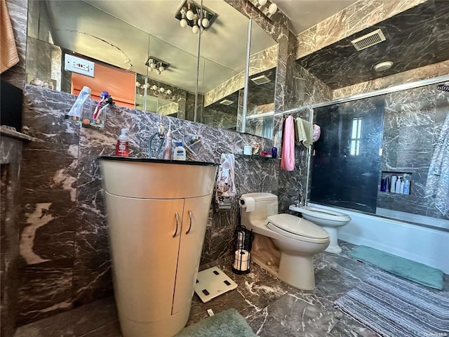 full bathroom with vanity, shower / bath combination with glass door, a bidet, toilet, and tile walls