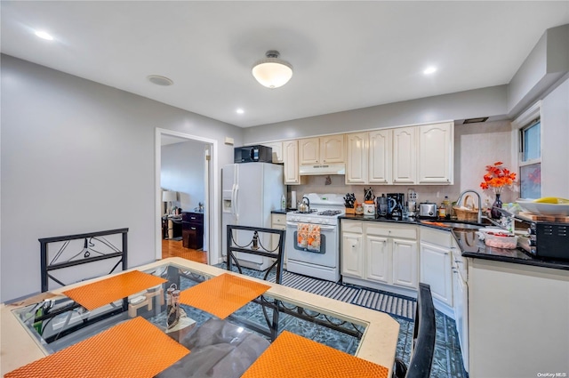 kitchen with sink, white cabinets, and white appliances