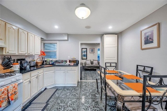 kitchen with sink, white range with gas stovetop, and ventilation hood