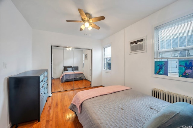 bedroom featuring multiple windows, ceiling fan, a closet, and light wood-type flooring