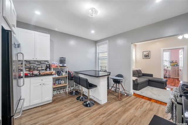 kitchen with light hardwood / wood-style flooring, white cabinets, and appliances with stainless steel finishes