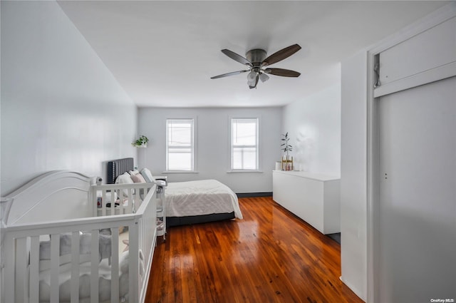 bedroom with dark hardwood / wood-style flooring and ceiling fan