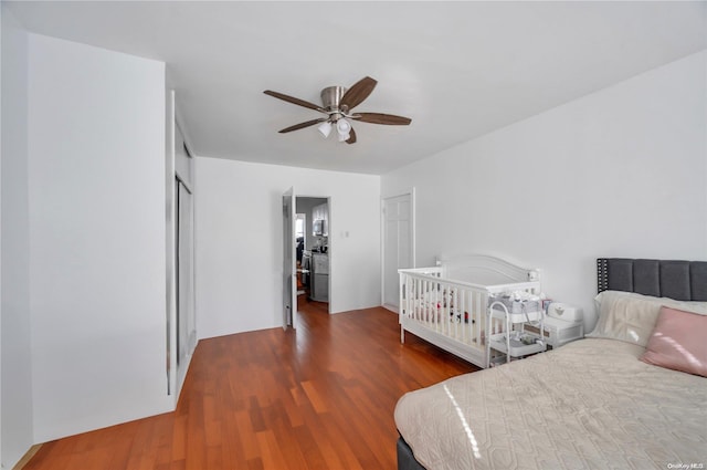 bedroom featuring a closet, ceiling fan, dark hardwood / wood-style flooring, and a crib